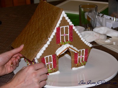 Pipe royal icing on all the edges the roof will attach to. Place roof on top and hold in place until stable.